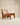 Low wooden lounge chair with angular V-leg frame and cane backrest and seat, walnut finish — handcrafted Kangaroo-style chair made in India.