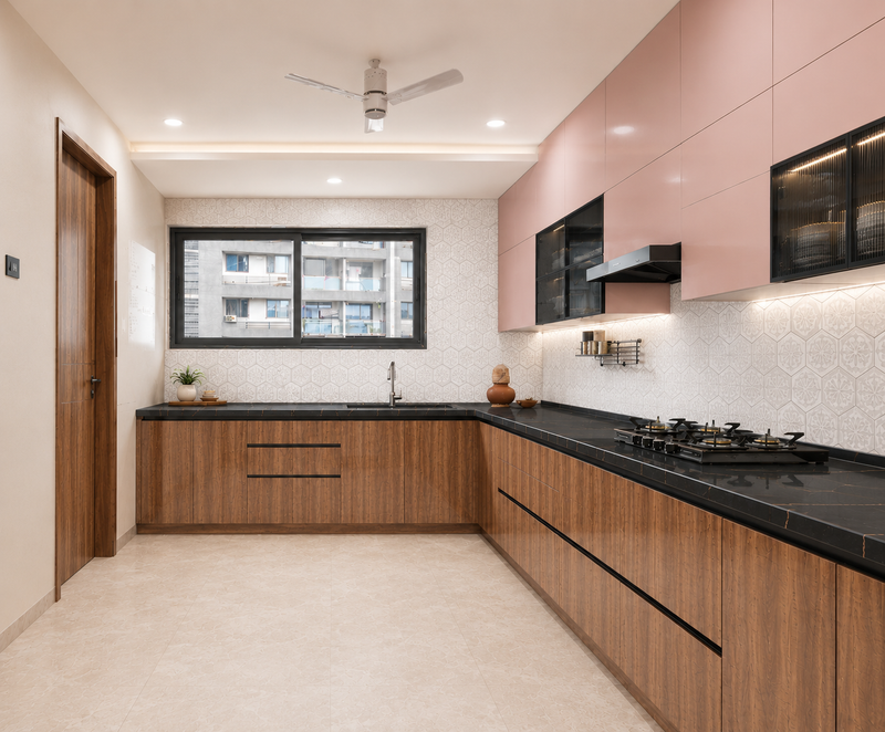 Modern kitchen with pink and wooden cabinets, black countertops, and a window.