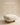 Pebble-shaped cream upholstered ottoman with round wooden ball feet, natural wood finish — handcrafted accent stool made in India.