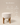 Round upholstered cream stool with arched wooden leg base, natural wood finish — handcrafted accent stool made in India.