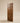 Front view of a contemporary walnut wooden entrance door with vertical panels, decorative horizontal grooves, and rich natural wood grain.