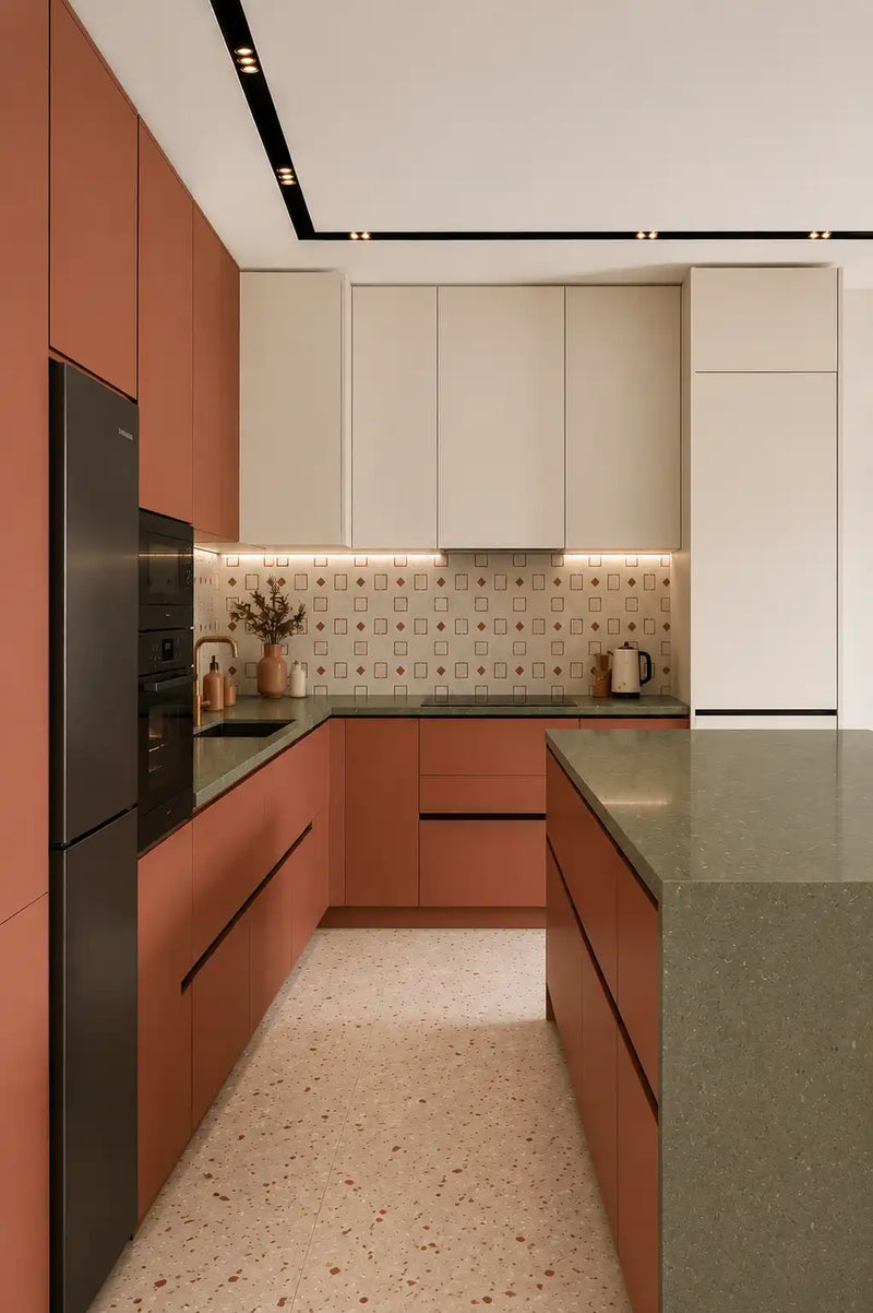 Modern kitchen with pink cabinetry, black appliances, and a patterned backsplash.